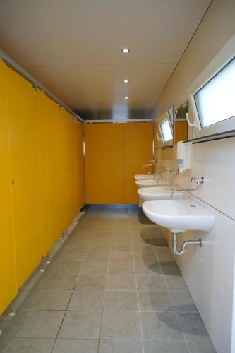 BockholtzSafaritent op Camping Berkel的浴室里一排黄色墙壁的水槽