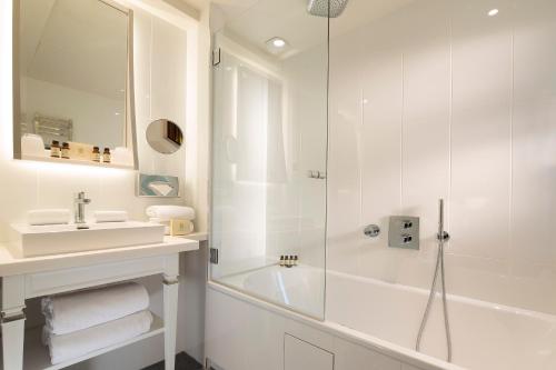 巴黎波美酒店的带淋浴和盥洗盆的白色浴室