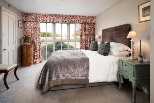 莫珀斯Throphill Grange的一间卧室设有一张大床和一个窗户。