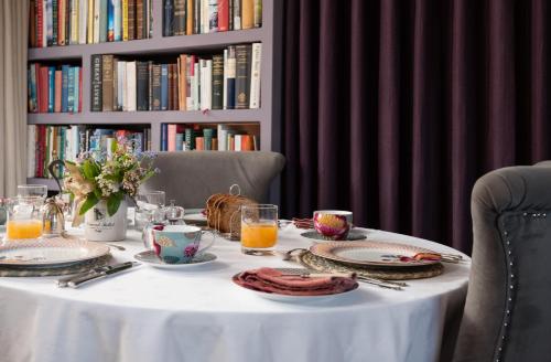莫珀斯Throphill Grange的一张带食物盘的白色桌子和一个带书籍的书架