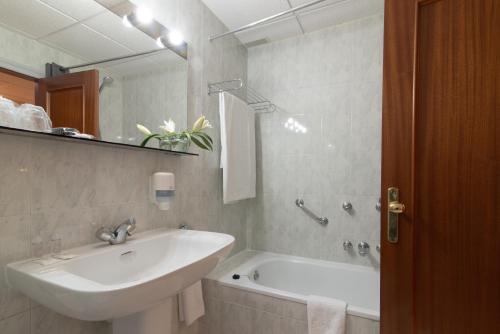 马格兹德皮苏尔歌Hospedium Hotel Europa Centro的一间带水槽、浴缸和镜子的浴室