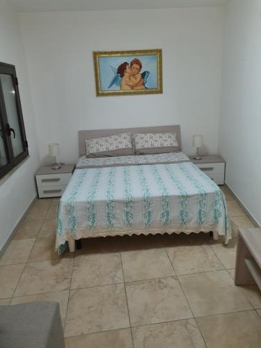 CampomarinoNel Cuore di Campomarino的卧室配有1张床和2张桌子,墙上挂着1张照片