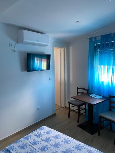 奈维斯Apartmani Bella Vista的一间设有桌子和蓝色墙壁的客房
