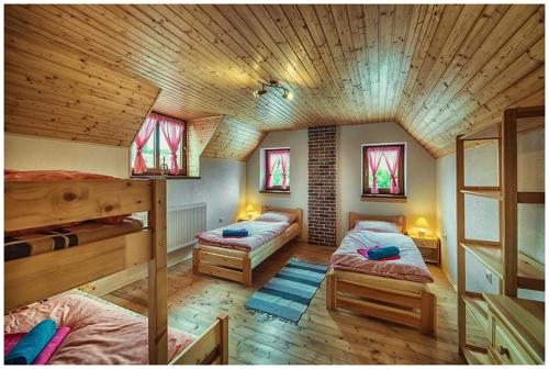 DúbravaChata Margitka的一间卧室设有两张双层床和木制天花板。