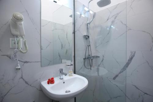 雷夫卡达镇Apartments Avra的白色的浴室设有水槽和淋浴。