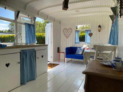 东福尔讷Little blue house (on the campsite)的厨房和带桌子的客厅