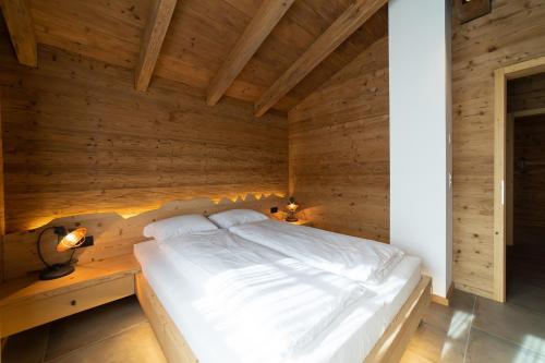 维尔德豪斯Chalet Brisi的卧室配有木墙内的一张床