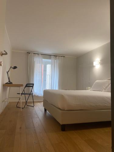 都灵Santantonio Suite, Porta Susa的一间卧室配有一张床、一张书桌和一个窗户。