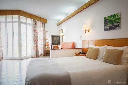 卡纳斯·德·塞尤里Pantanha Studio by Trip2Portugal的卧室配有一张白色大床和电视。