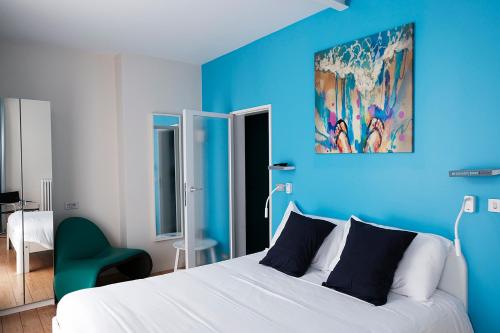 奥斯坦德Villa Les Paquerettes的蓝色的卧室设有白色的床和蓝色的墙壁