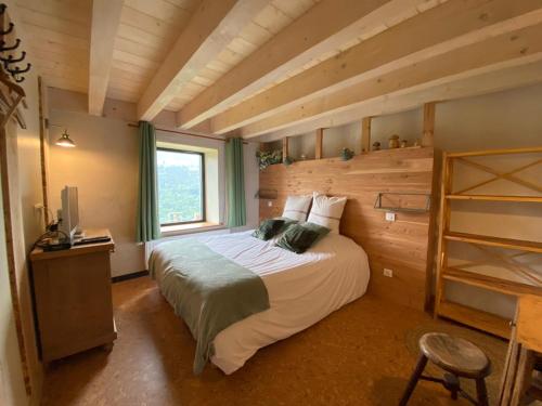 科尔尼蒙拉弗尔梅锁斯勒斯海兹旅馆的一间卧室设有一张带木墙的大床
