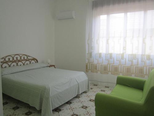 拉卡莱Don Vito的卧室配有床、椅子和窗户。