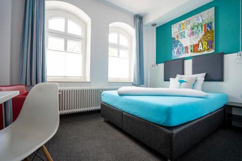 吕登沙伊德吕登沙伊德 斯塔德酒店的一间卧室配有蓝色的床和椅子