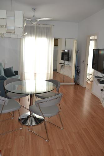 马拉加Apartamento Barrio Picasso的客厅配有玻璃桌和椅子
