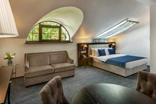 莫斯科Seasons Boutique Hotel的一间卧室配有一张床、一张沙发和一个窗口