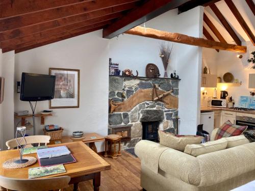 班戈Mountainstudios Beudy Bach & Beudy Mawr的客厅设有石制壁炉和桌子。