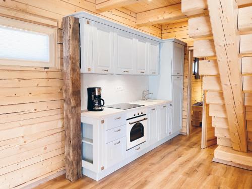 拉多夫吉卡Log House Natura的小木屋内的厨房配有白色橱柜