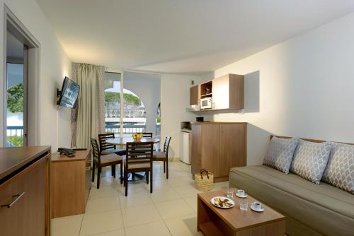 拉格朗德默特瑞斯迪尔大丛林公寓酒店的客厅以及带沙发和桌子的厨房。