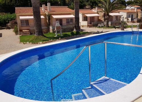 霍斯皮塔勒·德尔英福Beach Resort La Margarita的一座大型蓝色游泳池,位于房子前面,设有楼梯
