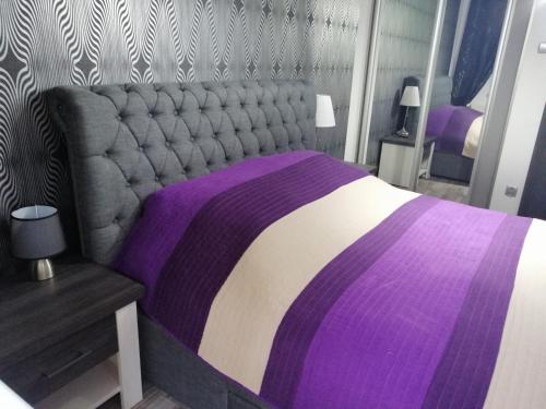 科沃布热格Apartament Nadmorski的卧室配有紫色和白色的床和桌子