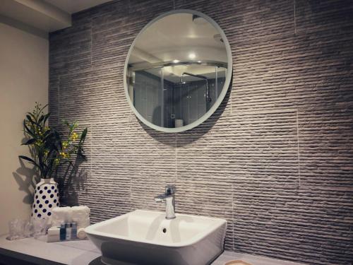 博格诺里吉斯Beach Hut Suites的浴室设有水槽和墙上的镜子