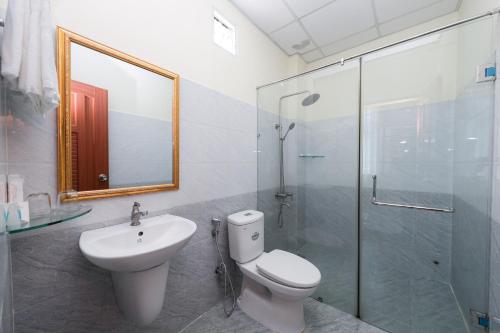胡志明市Minh Hoang Hotel的浴室配有卫生间、盥洗盆和淋浴。