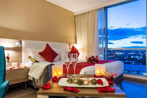 库库塔Holiday Inn Cúcuta, an IHG Hotel的酒店客房,配有一张床和一张桌子,上面有盘子的食物
