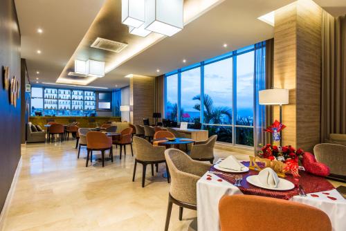 库库塔Holiday Inn Cúcuta, an IHG Hotel的餐厅设有桌椅和大窗户。