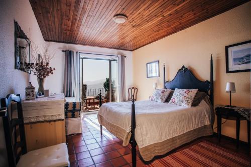 丰沙尔Apartamento Charmoso no Funchal, com grande Jardim e Vista Esplêndida的一间卧室设有一张床和一个大窗户