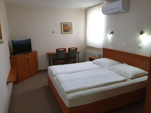 克拉尼Dežman Apartments & Rooms的一间卧室配有一张床、两把椅子和电视