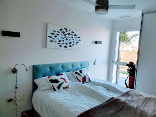 弗拉门卡海滩Sea Golf Sun Luxury Vacation Rental的一间卧室配有一张带蓝色床头板的床和窗户