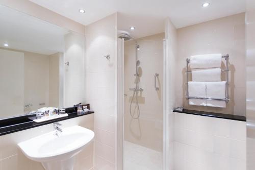 谢菲尔德谢菲尔德圣保罗Spa美居酒店的白色的浴室设有水槽和淋浴。