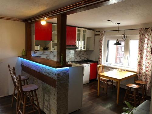 ReinhardtsdorfFerienhaus-Elisabeth Bungalow-Tom Bungalow-Peter的厨房配有红色橱柜和桌椅