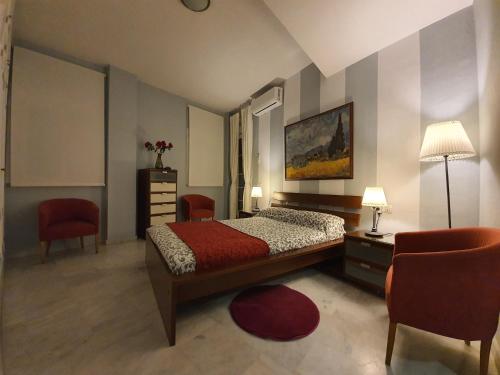 塞维利亚阿提科圣克莱门特公寓的一间卧室配有一张床、两把椅子和一张桌子