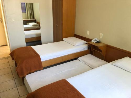 戈亚尼亚Hotel Serra das Águas的带两张床和镜子的客房
