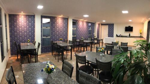 戈亚尼亚Hotel Serra das Águas的餐厅内带桌椅的用餐室