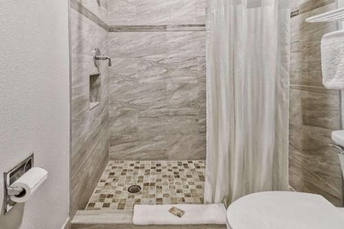 海恩斯城海恩斯城罗德威套房酒店的带淋浴、卫生间和盥洗盆的浴室