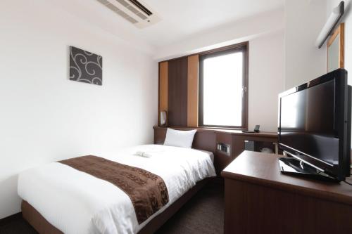 福冈东洋酒店的配有一张床和一台平面电视的酒店客房