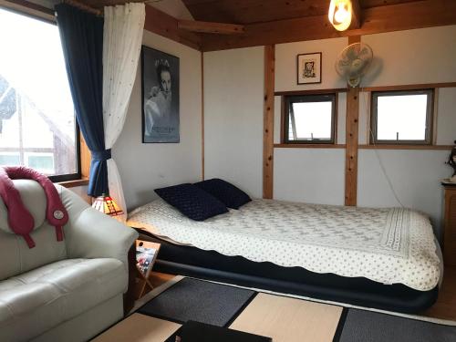 富山ヨーコのお宿 わくわく的一间卧室配有一张床和一张沙发