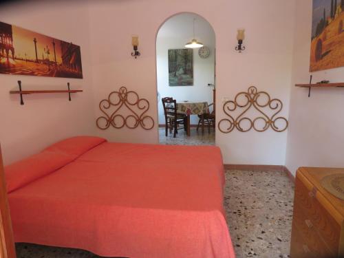 坎普码头I GECHI - MARINA DI CAMPO的一间带红色床的卧室和一间用餐室