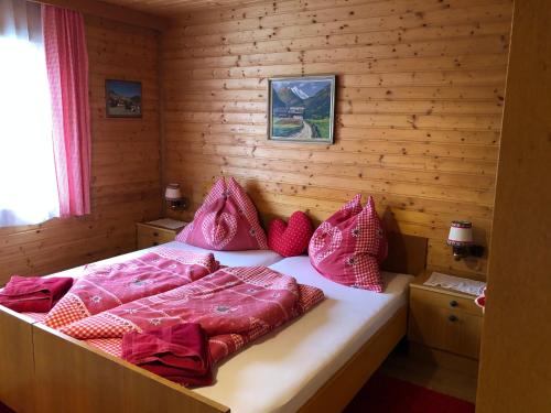 海利根布卢特Villa Brandstätter的一间卧室配有一张带粉色床单和枕头的床。
