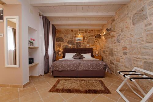 尼亚卢卡特林塔科尔丘拉旅馆的卧室配有一张石墙床