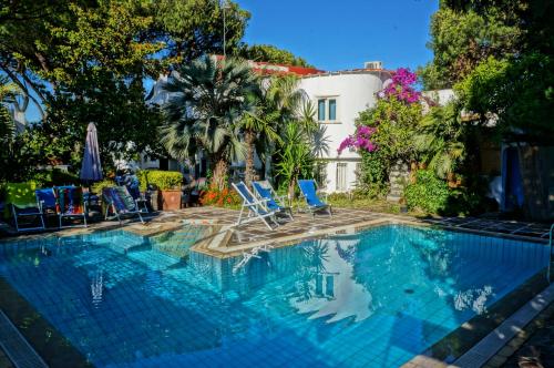 伊斯基亚Villa Cinque Pini的一个带椅子的游泳池以及一座房子