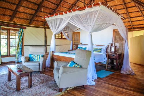 SaadaniSaadani Safari Lodge的一间卧室配有一张带天蓬的床