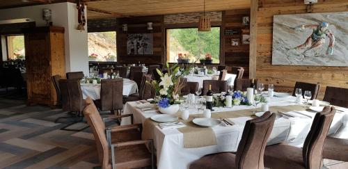伊索拉2000Chalet Marano Restaurant & Spa的一间设有白色桌椅的用餐室