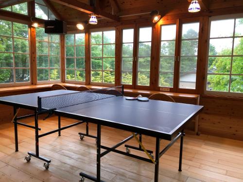 山中湖村Shinkaifujishoen的带窗户的客房内设有两张乒乓球桌
