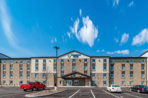 WhitestownWoodSpring Suites Indianapolis Zionsville的一辆红色卡车停在停车场的酒店