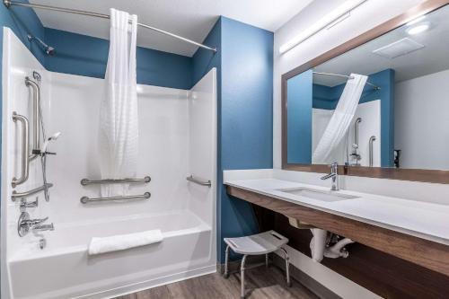 印第安纳波利斯WoodSpring Suites Indianapolis Castleton的带浴缸、水槽和镜子的浴室