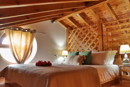 阿斯特里斯Luminous Sky Appartments的一间卧室设有一张带木制天花板的大床