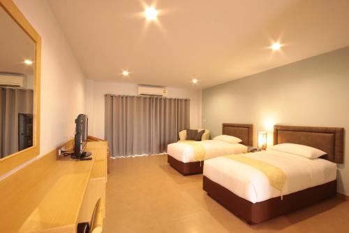 乔木提恩海滩百诺肯套房度假酒店的酒店客房设有两张床和一台平面电视。